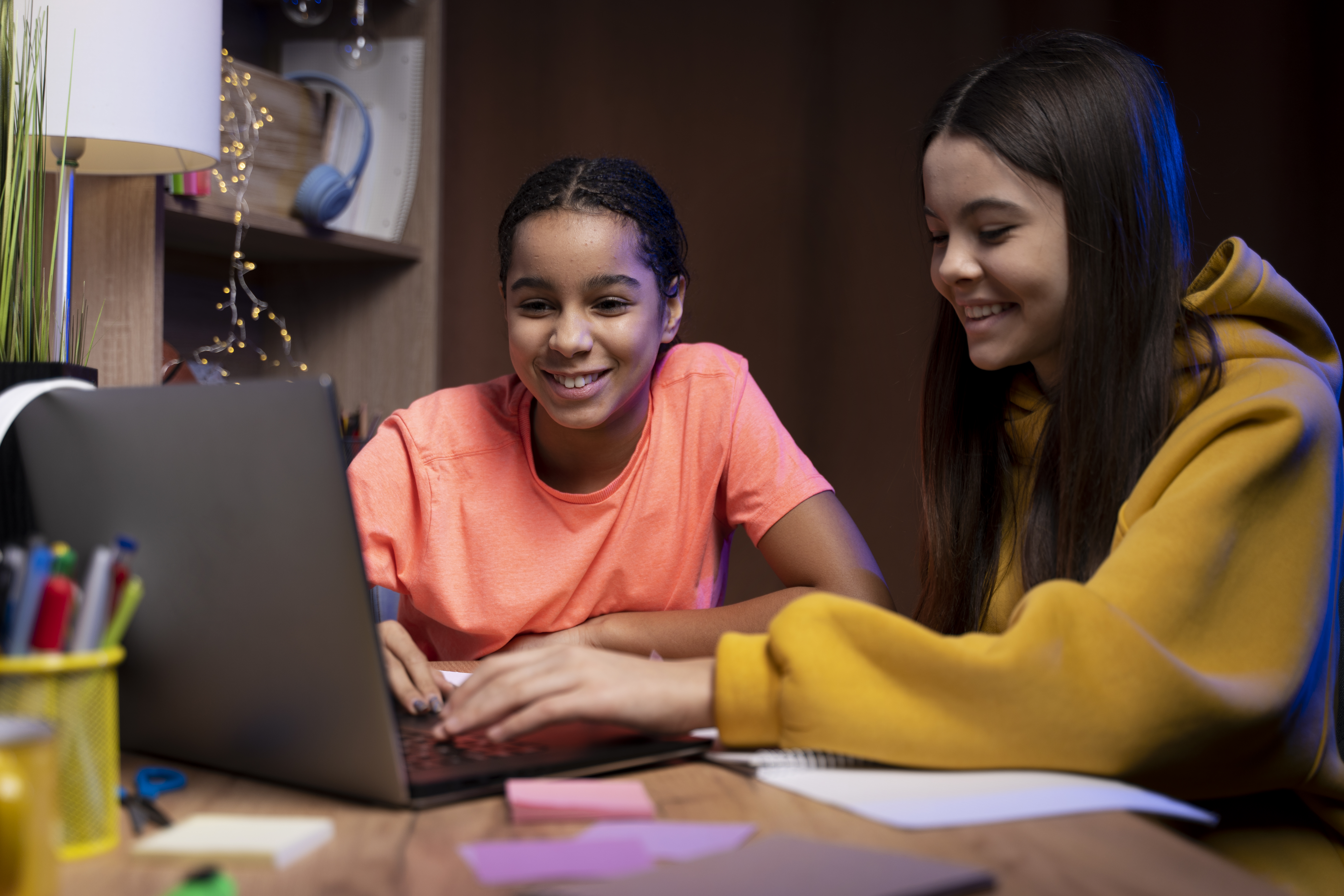 two teenage girls studying together home laptop (1)