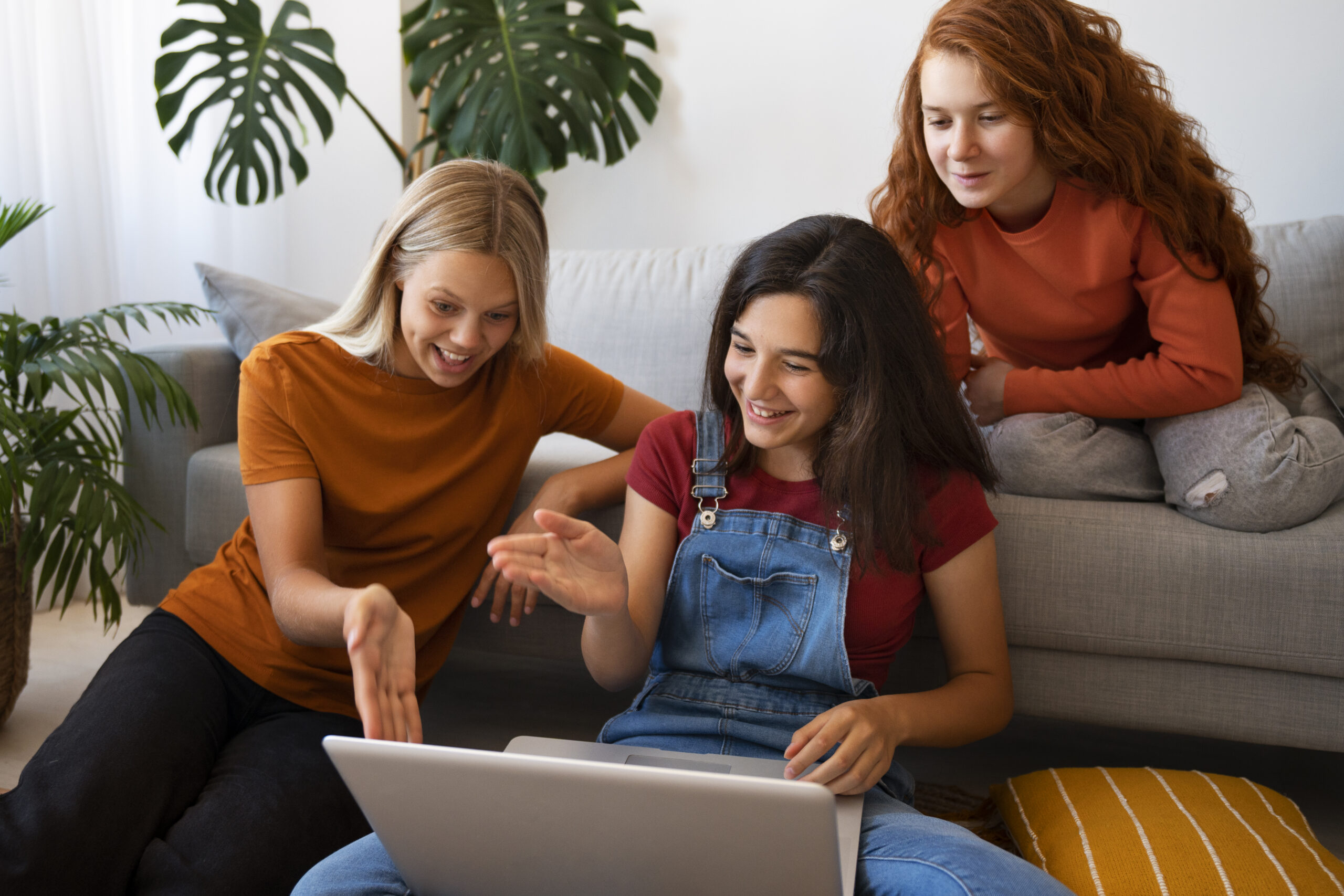 smiley girls sitting indoors high angle